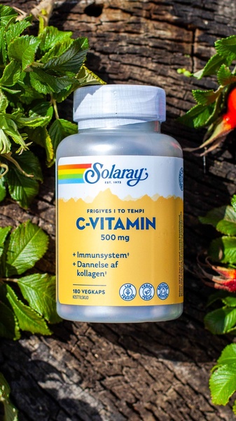 A 9:16 vertical product shot featuring a bottle of Vitamin C centered against a natural, rustic tree bark and green leaves background.